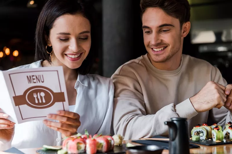 um casal a escolher a refeição que vai pagar com um cartão refeição