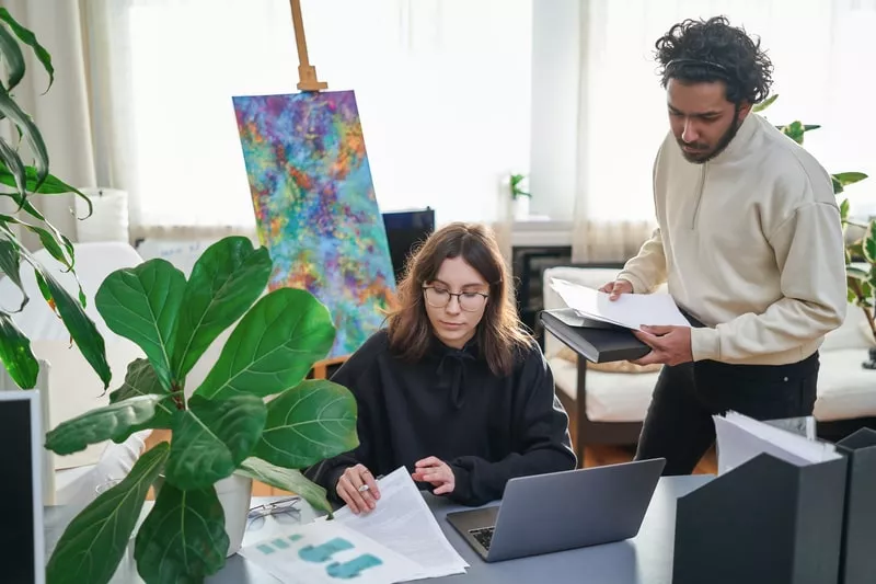 dois funcionarios que recebem beneficios flexíveis a trabalhar num escritorio