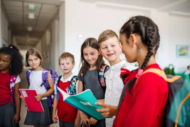 crianças a aguardarem no corredor da escola 