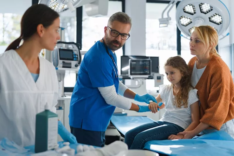 mãe na sala de hospital numa consulta para a filha, utilizando o seguro de saude da empresa 