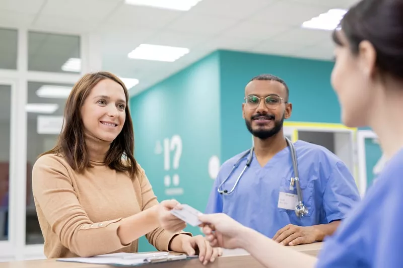 mulher na receção de um hospital a utilizar o seguro de saude da empresa 