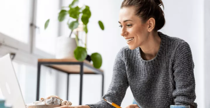mulher feliz a olhar para o computador