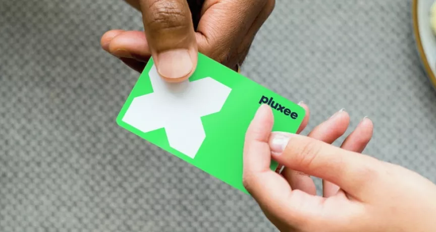 cartão refeição da pluxee sendo segurado por duas mãos diferentes