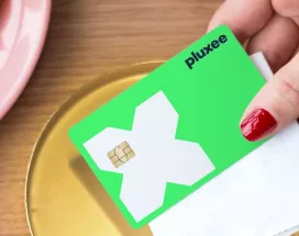 a mão de uma mulher a segurar o cartão refeição da pluxee