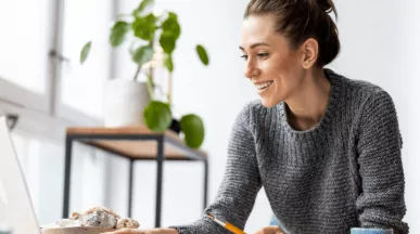 mulher feliz a olhar para o computador