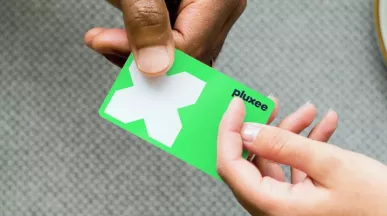 cartão refeição da pluxee sendo segurado por duas mãos diferentes